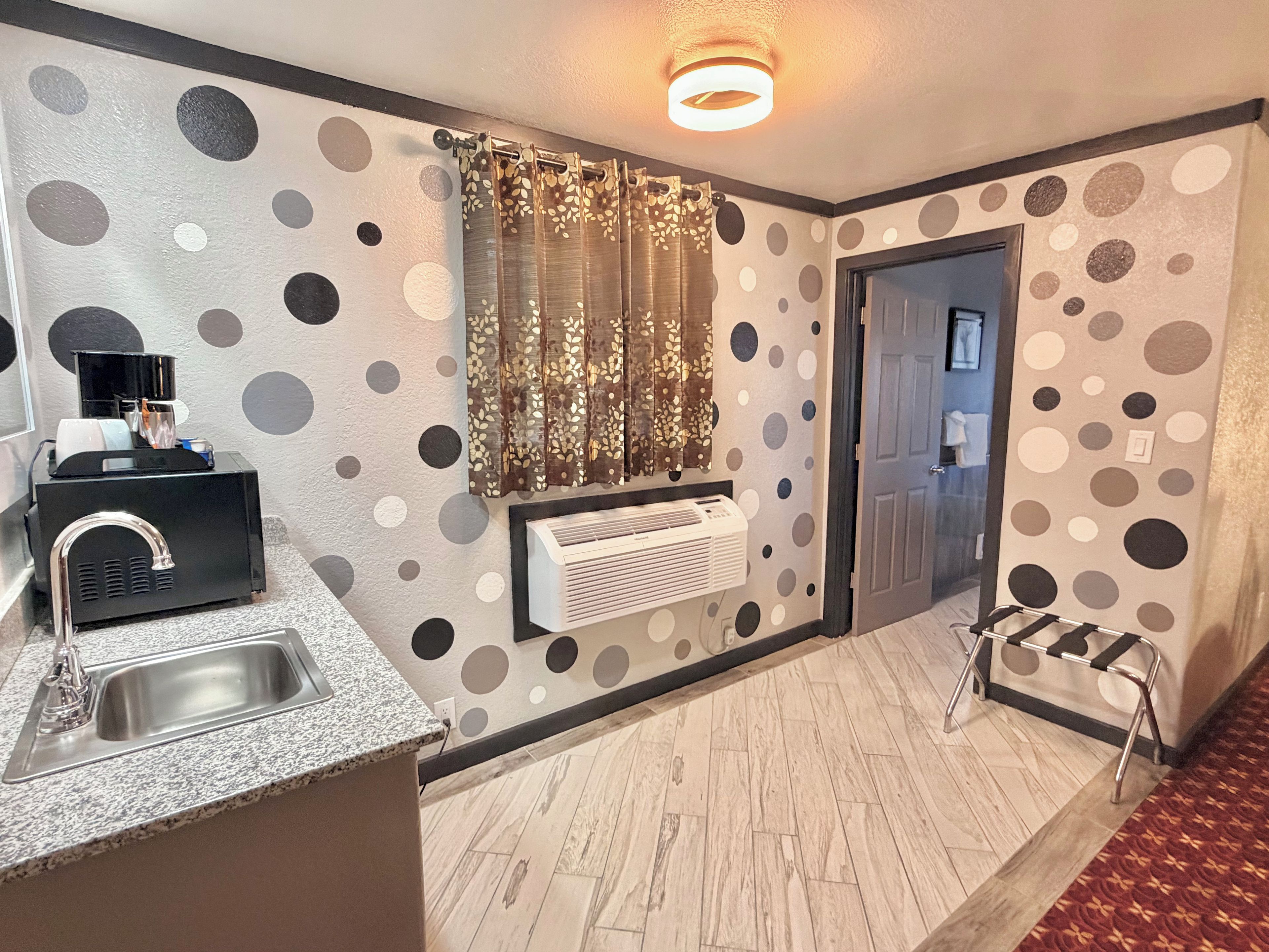 A modern kitchen with a built-in sink, a coffee machine, and an air conditioning unit.