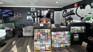 A room with a desk, shelves with books, a fish tank, and a wall with a 'Cascade Lodge' sign. - Cascade Lodge Boutique (Bend)