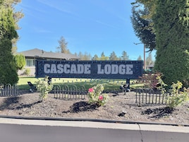 Un letrero de madera que indica el nombre del establecimiento, 'Cascade Lodge'.
