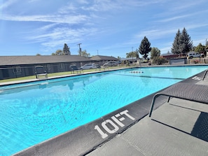 Une piscine équipée d’un poste de surveillance pour sauveteur et d’une indication de profondeur indiquant « 3 mètres ».