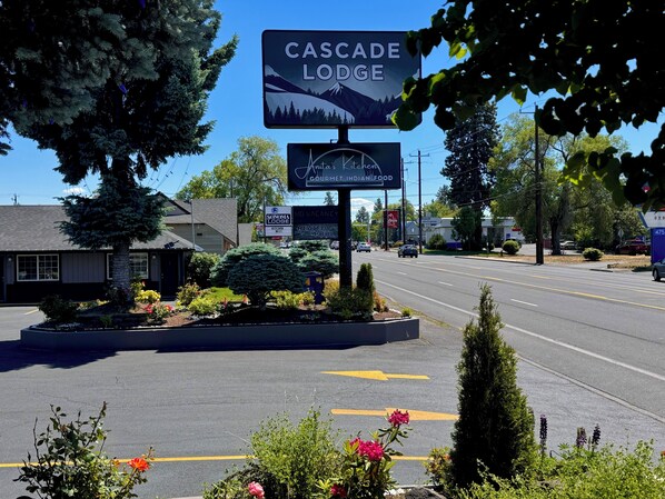 A roadside sign for Cascade Lodge and a restaurant named Indian Cuisine.
