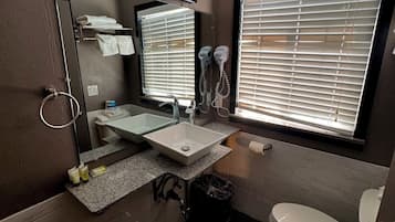 A bathroom with a sink, mirror, towel rack, and toilet.