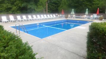 Alberca al aire libre, sombrillas en la alberca y camastros