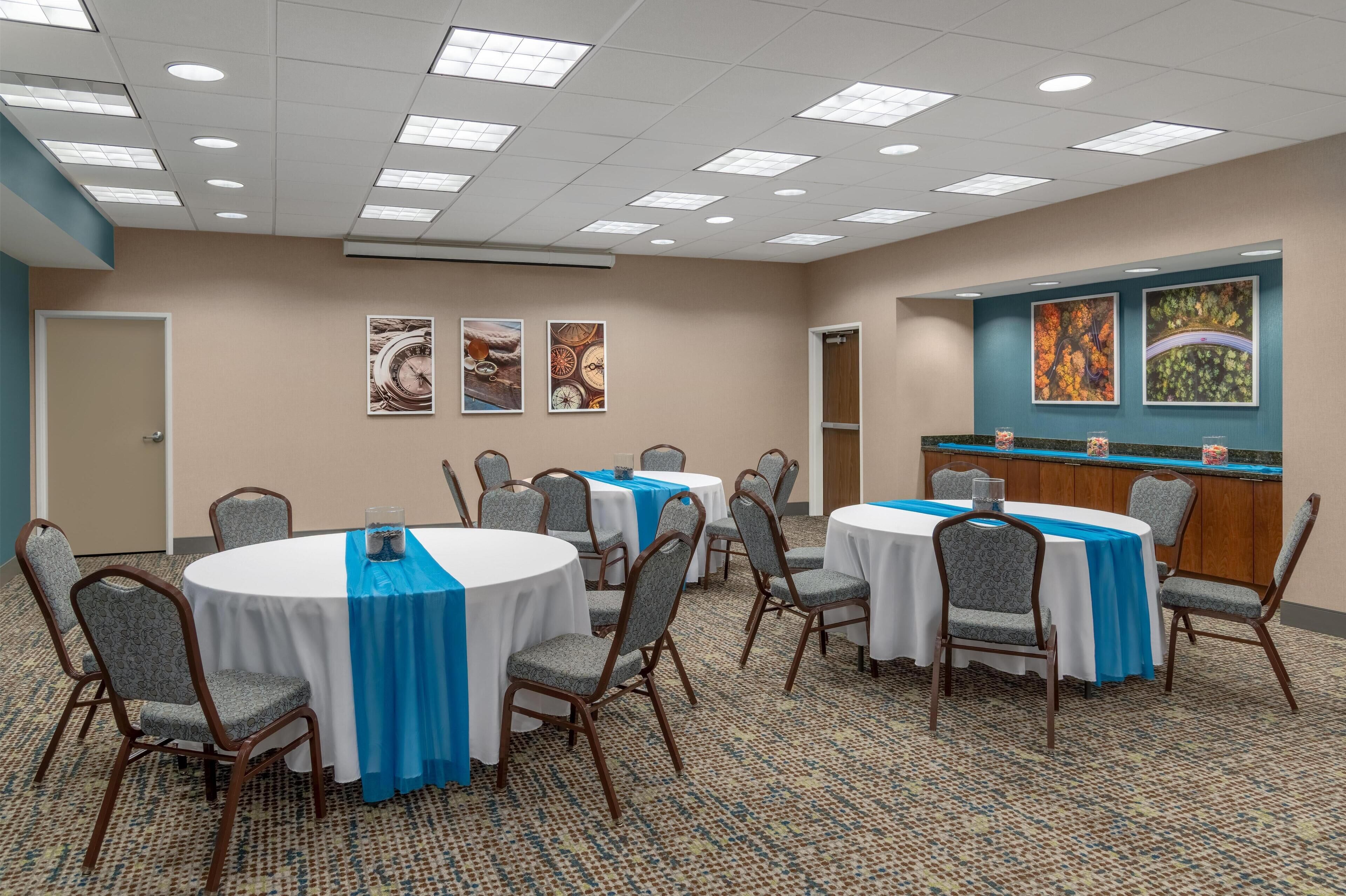 A conference room with round tables, chairs, and a reception desk.