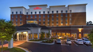 A multi-story hotel with a brick facade and a large entrance.