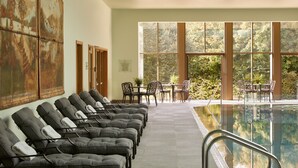 Un área de spa con sillones reclinables, una piscina y vistas al exterior.