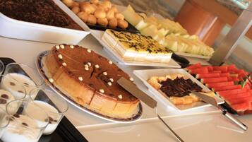 Een buffet met diverse desserts, waaronder chocoladetaart, fruit en gebak.