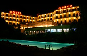 A hotel with a swimming pool and lounge chairs. - Hotel Grecs (Roses)