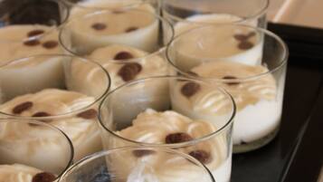 A tray of desserts including a cake and parfaits in glasses.