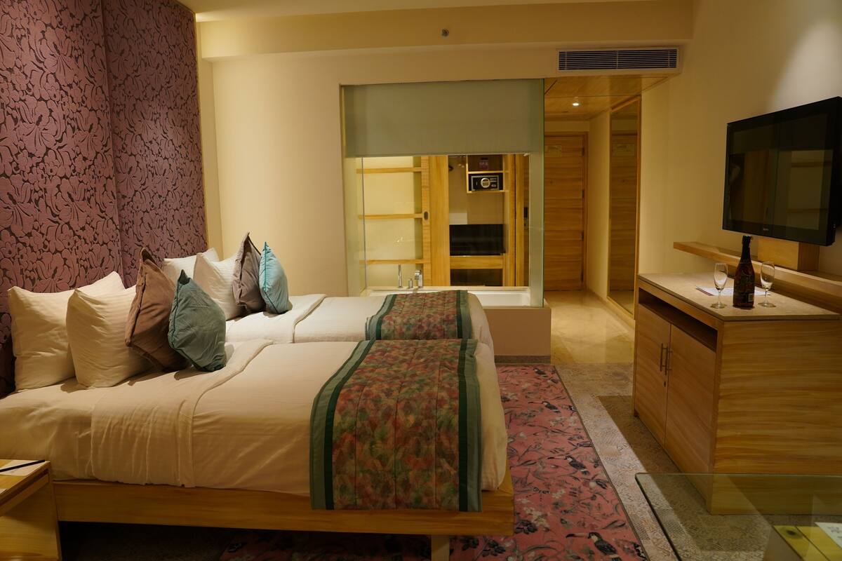 Een hotelkamer met een bed, een televisie, een badkamer en een bureau.