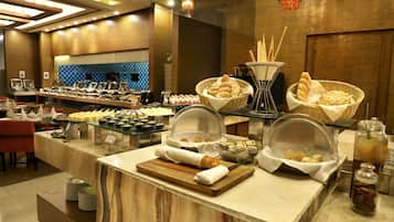 Enjoy a wide selection of food and beverages at our buffet, featuring multiple serving stations and a variety of fresh options.