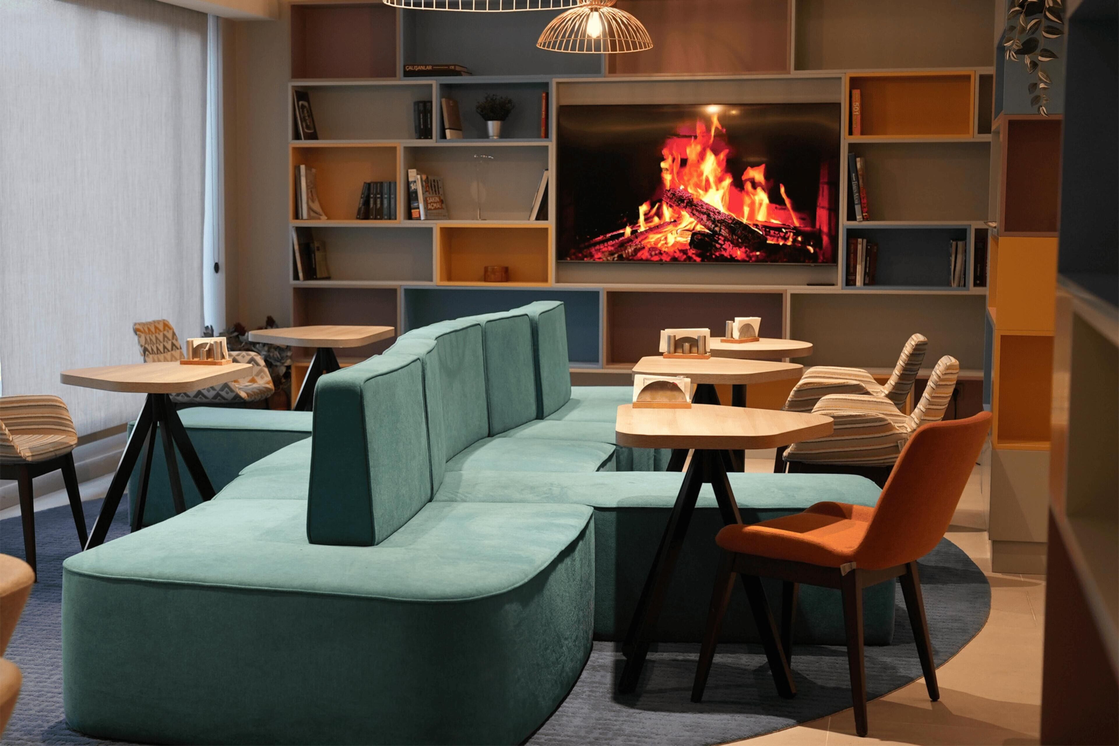 A modern living room with a sectional sofa, a flat-screen TV, and a fireplace.