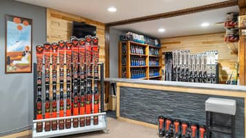 Un magasin d'articles de ski où l'on trouve des rangées de skis et de chaussures de ski.