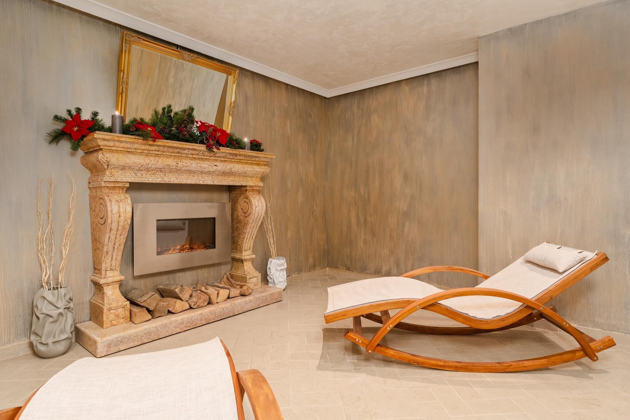 A modern living room with a fireplace, a large mirror, and two lounge chairs.