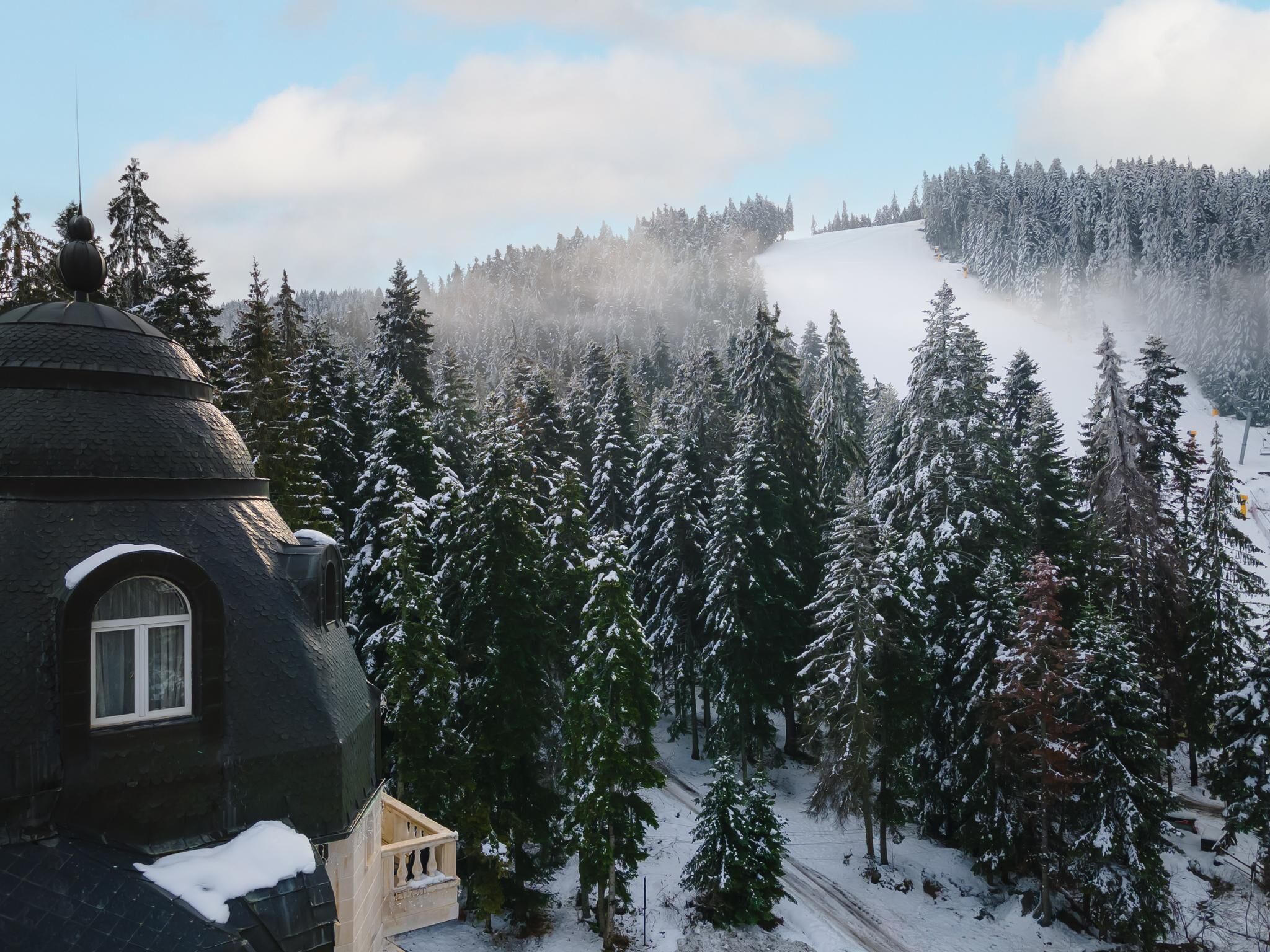 A snow-covered landscape with a building featuring a dome and a small annex.