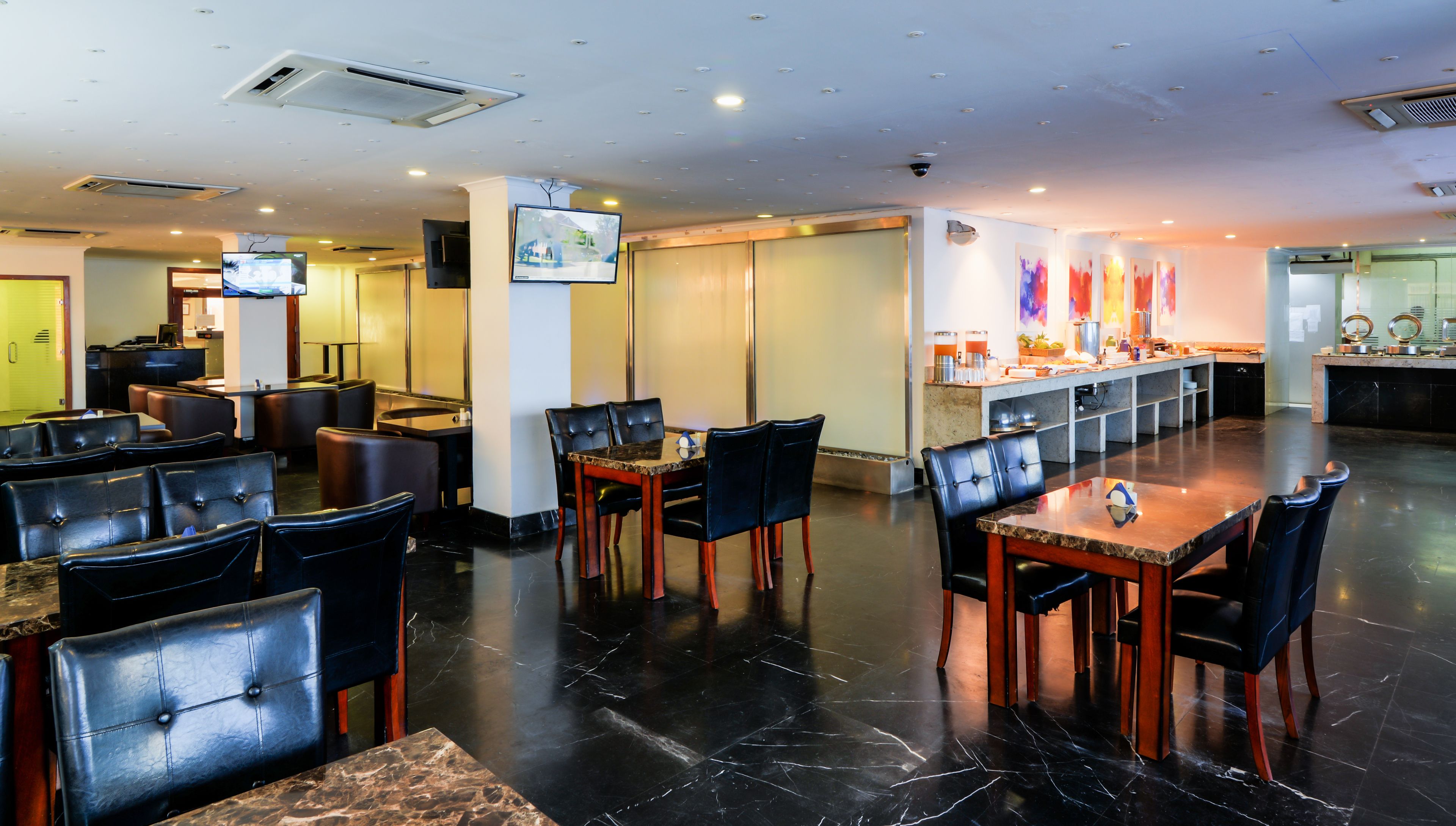 Un ristorante con pavimento in marmo, sedute in pelle e un'area buffet.