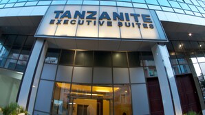 A modern building with a sign reading "TANZANITE EXECUTIVE SUITES".