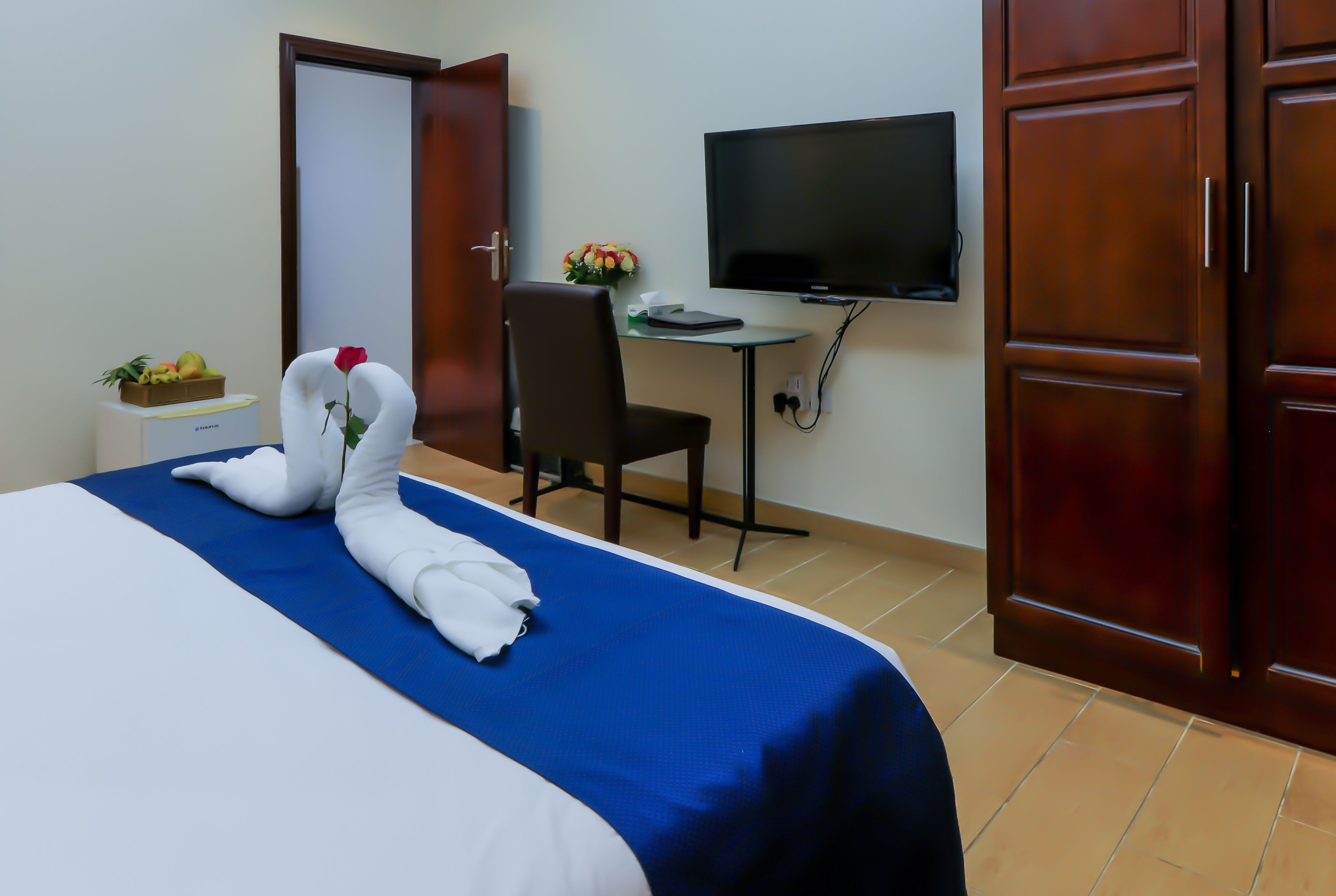 Une chambre d’hôtel équipée d’un lit, d’un bureau, d’une télévision et d’une armoire.
