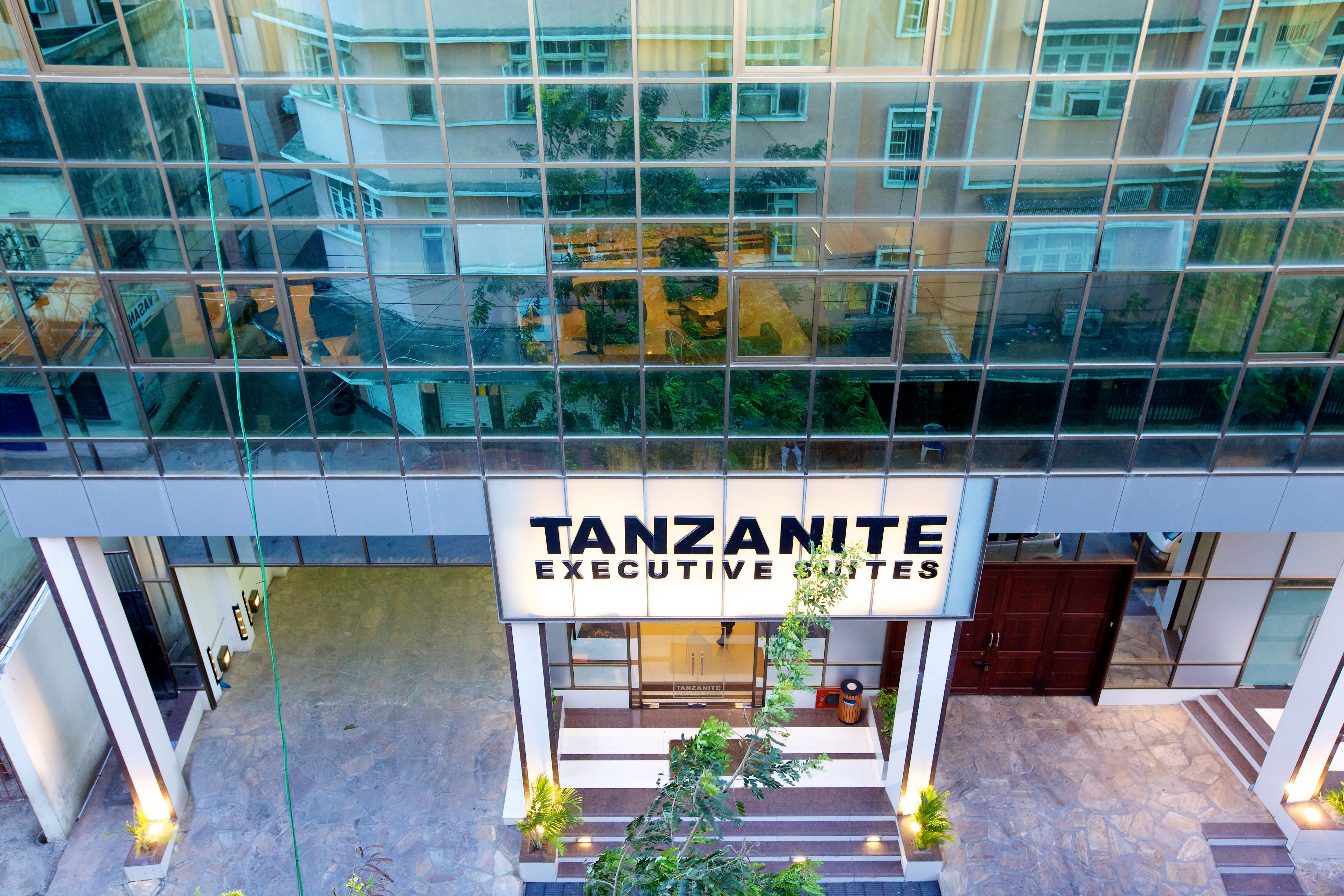 A modern building with a sign reading "TANZANITE EXECUTIVE SUITES".