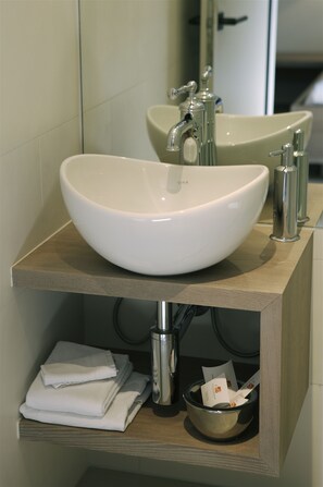 A modern bathroom with a large white sink, a mirror, and a wooden vanity. - Bad Bubendorf Hotel (Bubendorf)