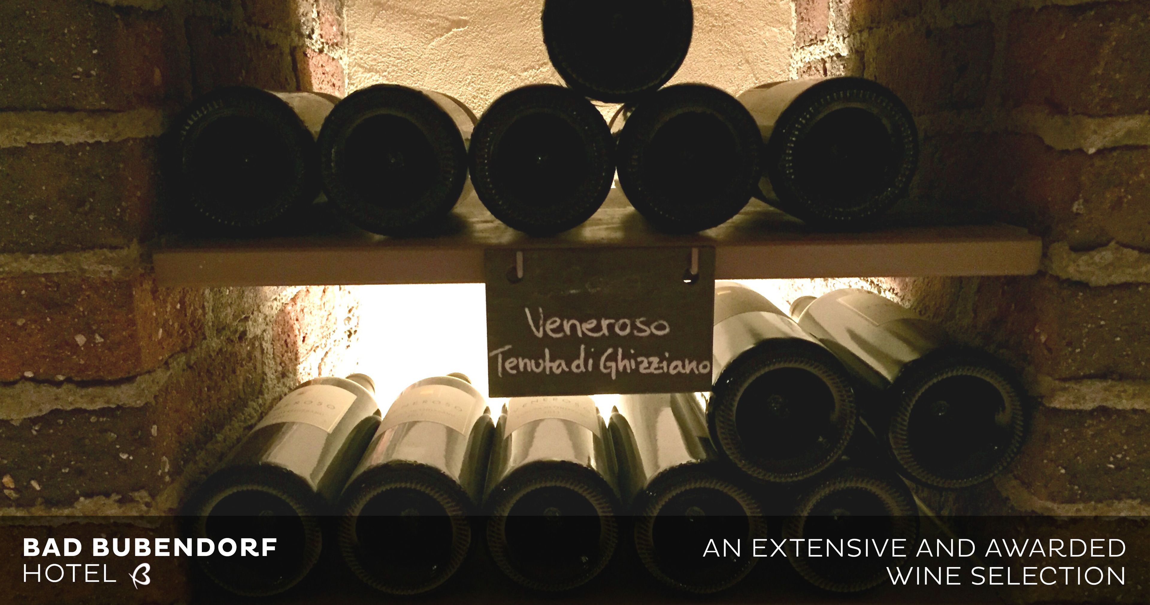 Un présentoir à bouteilles de vin, avec des bouteilles et une pancarte indiquant une sélection de vins à l’hôtel Bad Bubendorf.