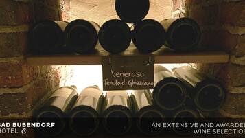 Un présentoir à bouteilles de vin, avec des bouteilles et une pancarte indiquant une sélection de vins à l’hôtel Bad Bubendorf.