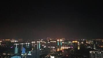 Un paisaje urbano nocturno con edificios iluminados y un puente.