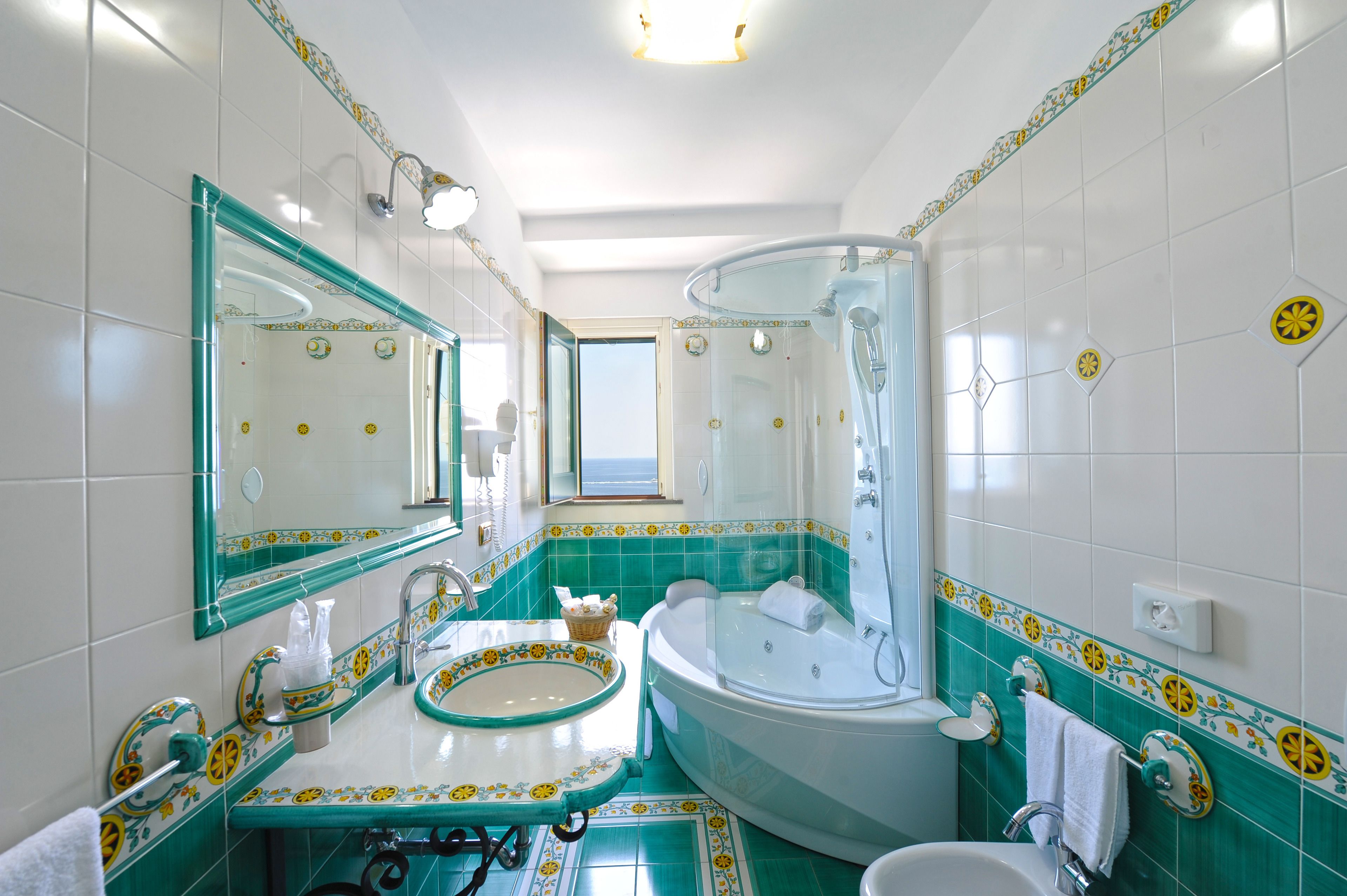 A bathroom with a large bathtub, a sink with a decorative bowl, and a shower with a glass enclosure.