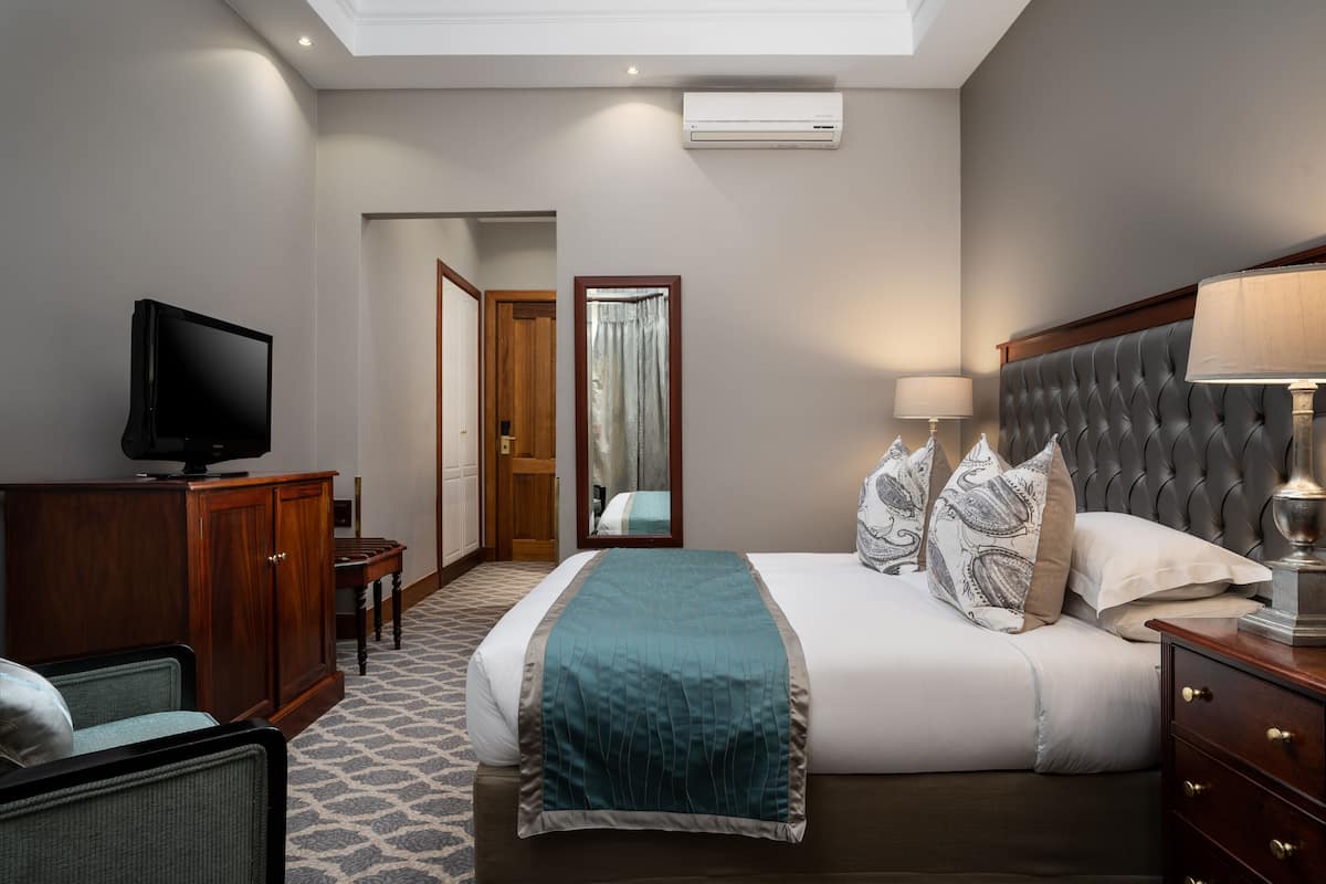 Een hotelkamer met een bed, een televisie, een bureau en een stoel.