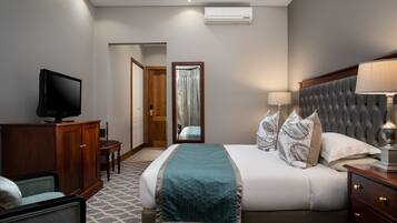 A hotel room with a bed, a television, a desk, and a chair.