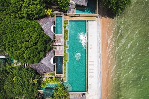 Una piscina al aire libre, sombrillas, sillones reclinables de piscina