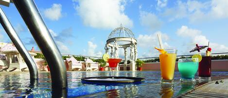 A poolside table with drinks and a decorative glass.