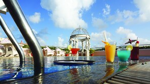 A poolside table with drinks and a decorative glass.