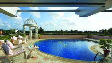 Una piscina al aire libre, sombrillas
