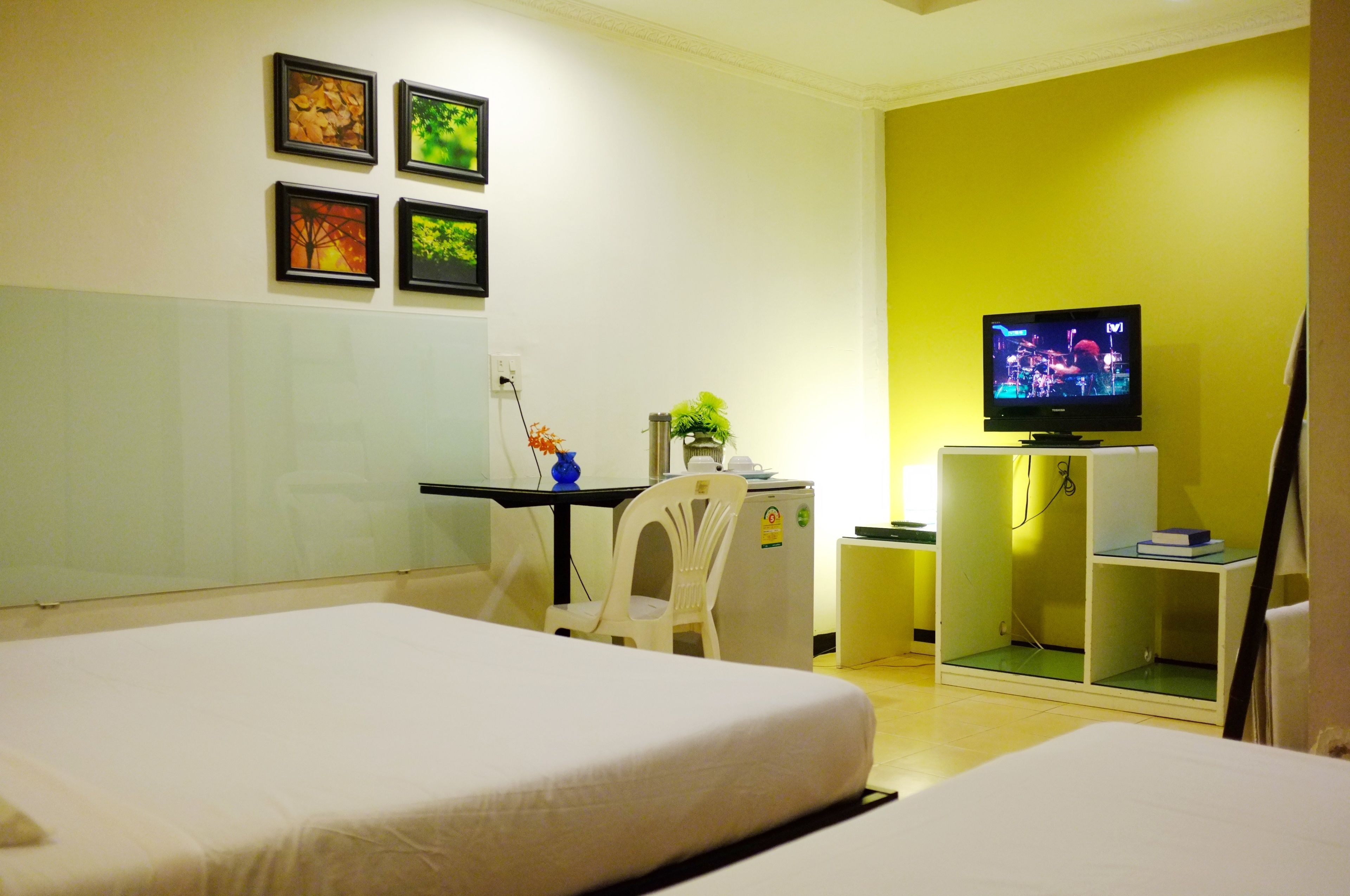 Une chambre d’hôtel comprenant un lit, un bureau avec une chaise, une télévision et un petit placard.