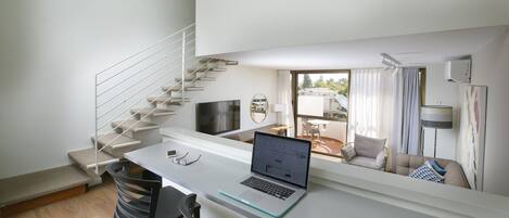 A modern apartment with a staircase, a dining area, a living room, and a balcony.