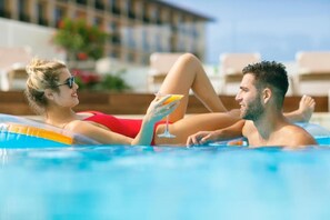Una piscina al aire libre de temporada, sombrillas