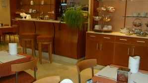 A restaurant with wooden tables, chairs, and a bar area. - Hotel Riviera (Segrate)