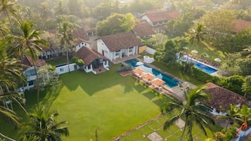 Zona residencial con piscina, varias casas y abundante vegetación.