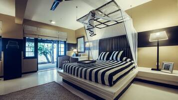 Un dormitorio moderno con cama con dosel, ventilador de techo y vistas al exterior.