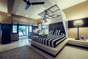 Ein modernes Schlafzimmer mit einem Himmelbett, Deckenventilator und Blick ins Freie.