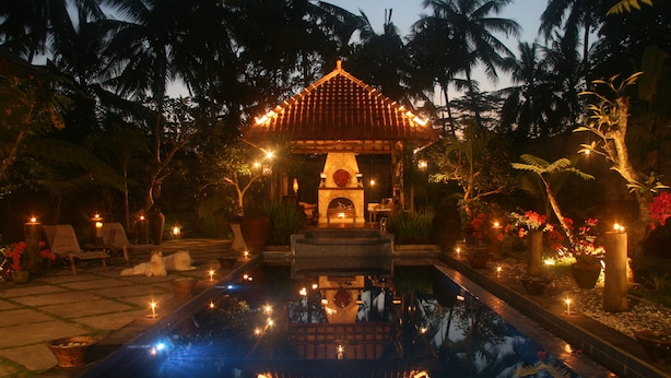 A serene pool area with a traditional gazebo, surrounded by palm trees and potted plants. - Villa Pakem (Pakem)