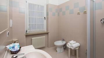 Un baño con lavabo, inodoro, bidé y zona de ducha.