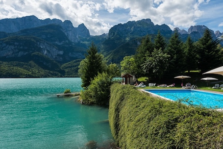 Una piscina al aire libre, sombrillas, tumbonas