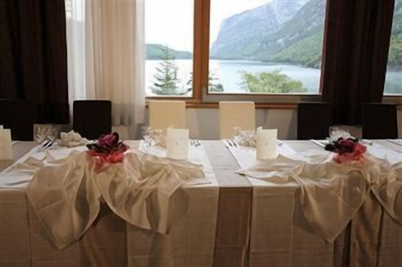 Une table dressée pour un repas, avec vue sur un lac et des montagnes.