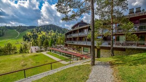 A modern hotel with a glass facade, multiple balconies, and a view of a green valley and mountains. - Hotel SPA Dr Irena Eris Krynica Zdrój 12+ (Krynica-Zdroj)