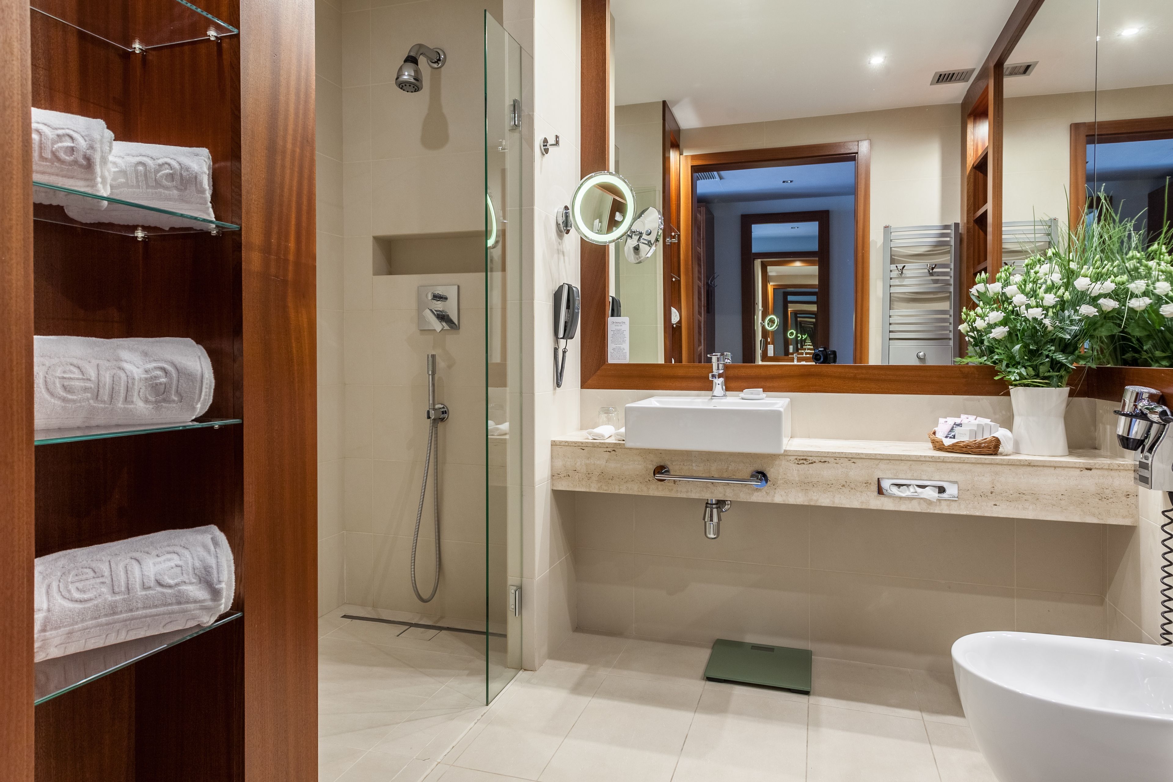 A modern bathroom with a glass shower enclosure, a vanity with a sink and mirror, and a toilet.