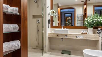 A modern bathroom with a glass shower enclosure, a vanity with a sink and mirror, and a toilet.