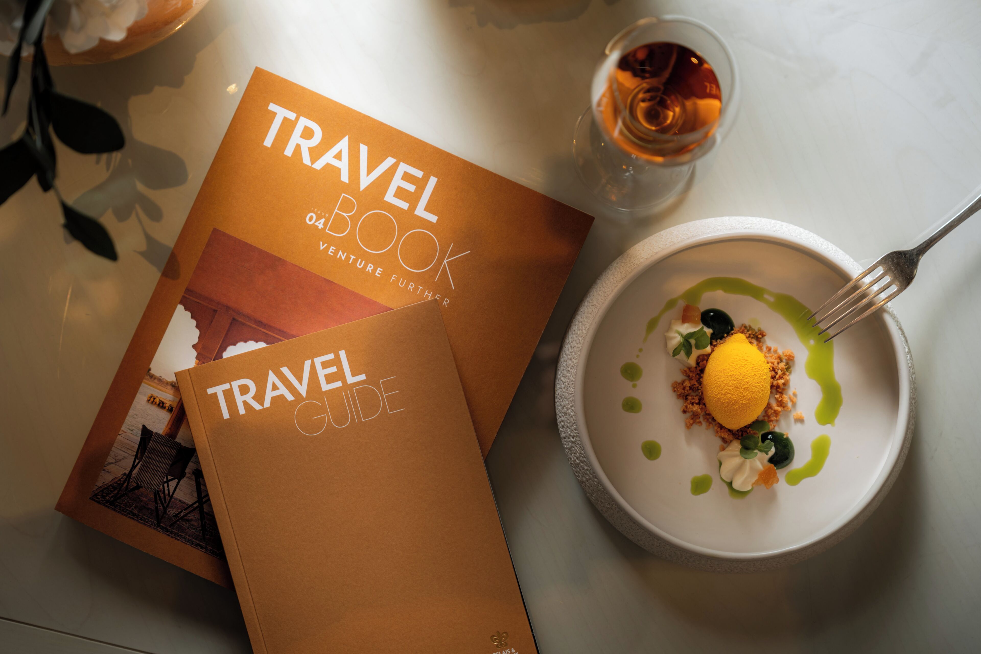 A travel guide book and a dessert on a table.