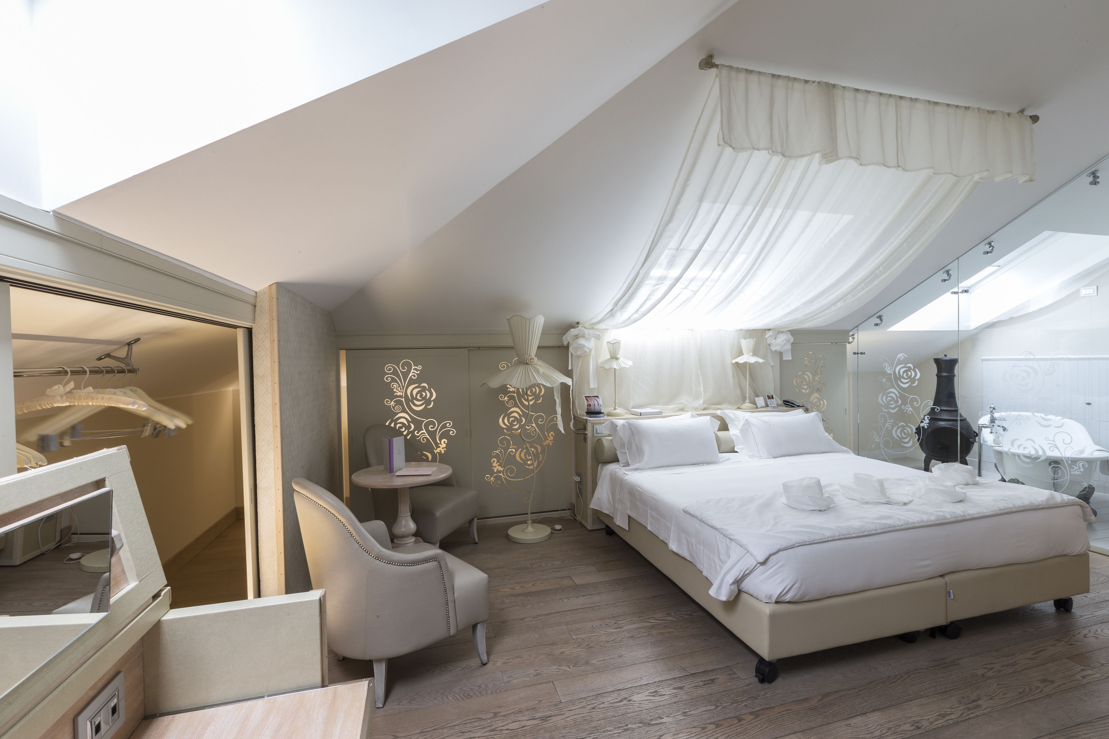 Un dormitorio moderno con una cama grande, un tocador y una bañera.